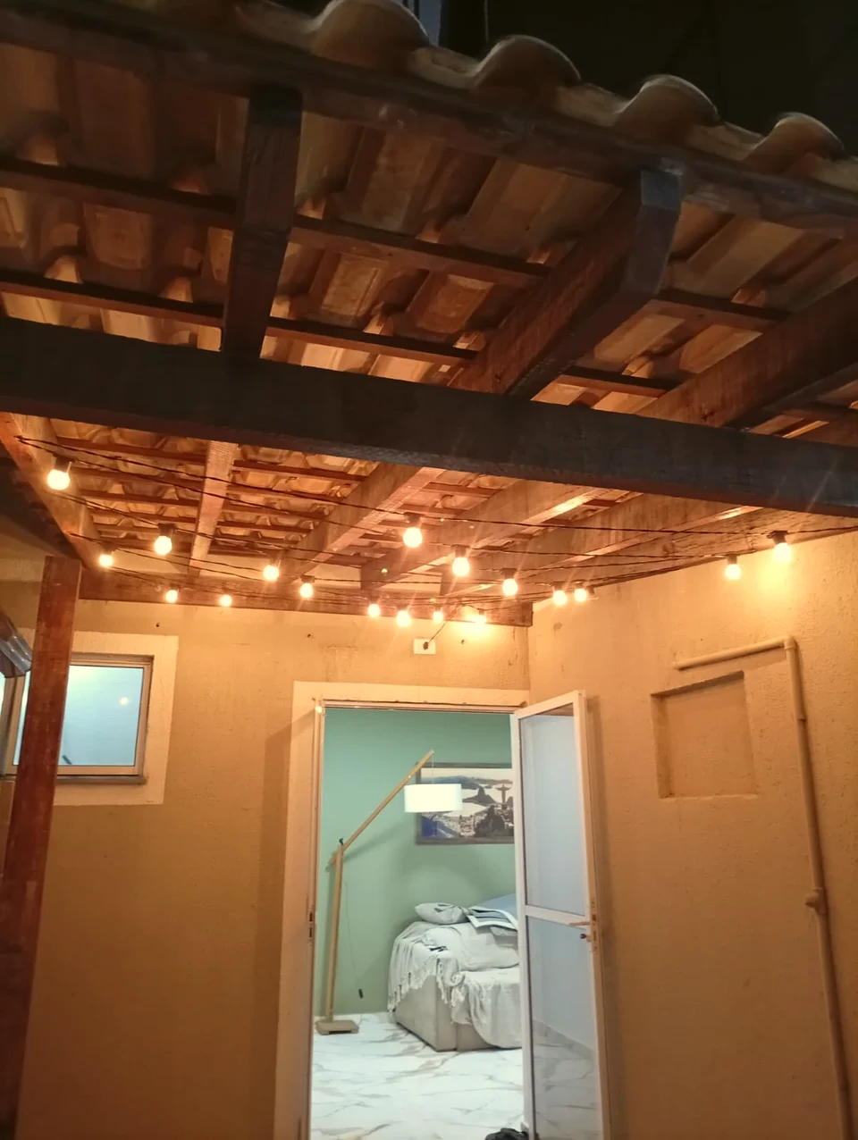 Forro de madeira com telhas cerâmicas e varal de luzes em cobertura feita pela JBT